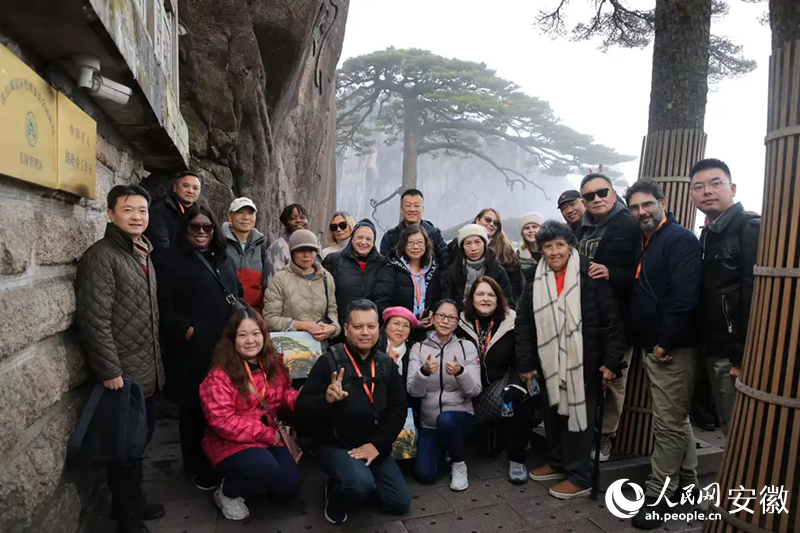 旅行商在黄山迎客松前合影。人民网记者 王晓飞摄